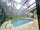 Inviting screened-in pool with lush greenery providing a relaxing outdoor experience at 10928 Echo Loop, New Port Richey, FL 34654
