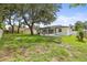 Spacious backyard featuring a covered patio, picnic table, and large shady trees at 4410 Lurline Cir, Tampa, FL 33610