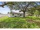 Lush backyard with large trees, a picnic table, and a view of the house with a covered patio at 4410 Lurline Cir, Tampa, FL 33610