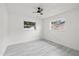 Bedroom featuring light grey flooring, two windows, and a ceiling fan at 4410 Lurline Cir, Tampa, FL 33610