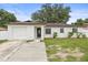 Charming single-story home features a stone accent wall, attached garage and inviting front lawn at 4410 Lurline Cir, Tampa, FL 33610