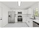 Bright kitchen featuring stainless steel appliances, white cabinets, and quartz countertops at 4410 Lurline Cir, Tampa, FL 33610