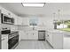 Kitchen features stainless steel appliances, white cabinetry, and open layout at 4410 Lurline Cir, Tampa, FL 33610