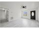 Bright living room with light grey flooring, ceiling fan, and a dark door with window at 4410 Lurline Cir, Tampa, FL 33610