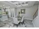 Bright dining room with marble flooring and modern chandelier at 7814 Hidden Creek Loop # 104, Lakewood Ranch, FL 34202