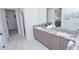 Modern bathroom with double vanity and view into walk-in closet at 7814 Hidden Creek Loop # 104, Lakewood Ranch, FL 34202