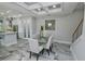 Modern dining area with marble flooring and glass table at 7730 Hidden Creek Loop # 102, Lakewood Ranch, FL 34202