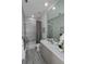 Modern bathroom with gray marble tile, bathtub, and vanity at 7834 Hidden Creek Loop # 104, Lakewood Ranch, FL 34202