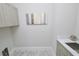 Bright laundry room with upper cabinets and a utility sink at 7834 Hidden Creek Loop # 104, Lakewood Ranch, FL 34202