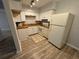 Galley kitchen with white cabinets and wood-look floors at 5380 4Th N St # 203, St Petersburg, FL 33703