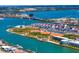 Panoramic aerial view of waterfront community with a baseball field, tennis courts, and canals on a sunny day at 15405 Gulf Blvd # B1, Madeira Beach, FL 33708