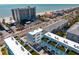 Stunning aerial view of modern condos with rooftop patios near the beach and a high-rise on a sunny day at 15405 Gulf Blvd # B1, Madeira Beach, FL 33708