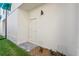 This newly landscaped backyard features an access door, a privacy fence, and green grass at 15405 Gulf Blvd # B1, Madeira Beach, FL 33708