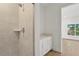 Modern bathroom with a tiled shower, floating vanity with a quartz countertop and a glimpse of the bedroom at 15405 Gulf Blvd # B1, Madeira Beach, FL 33708