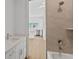 Bathroom featuring tub, shower, and vanity with modern finishes, plus kitchen in background at 15405 Gulf Blvd # B1, Madeira Beach, FL 33708