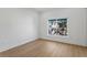 Bright bedroom featuring wood floors, white walls, and a window with a view of lush trees at 15405 Gulf Blvd # B1, Madeira Beach, FL 33708