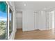 Bright bedroom featuring wood floors, white walls, and a window with a water view at 15405 Gulf Blvd # B1, Madeira Beach, FL 33708