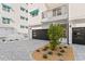 Modern condo exterior with stylish awnings and a paved courtyard leading to the garage at 15405 Gulf Blvd # B1, Madeira Beach, FL 33708