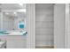 Bright bathroom featuring a tiled shower, vanity, and an open closet with shelving for optimal storage at 1200 Country Club Dr # 6103, Largo, FL 33771