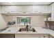 Bright kitchen with stainless steel sink and white cabinetry shows the interior design at 1200 Country Club Dr # 6103, Largo, FL 33771
