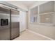 Modern kitchen featuring a stainless steel refrigerator, window, and neutral tiling at 1200 Country Club Dr # 6103, Largo, FL 33771