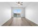 Bright bedroom with light wood floors, a ceiling fan and sliding glass doors to the balcony at 400 150Th Ave # 302, Madeira Beach, FL 33708