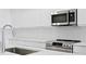 Close-up of a kitchen featuring stainless steel appliances and sleek white cabinetry at 400 150Th Ave # 302, Madeira Beach, FL 33708