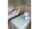 Two twin beds with light blue bedding, nightstand, and window at 3315 58Th S Ave # 218, St Petersburg, FL 33712