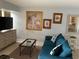 Living room with teal sofa, coffee table, and a large piece of wall art at 3315 58Th S Ave # 218, St Petersburg, FL 33712