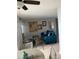 Open concept living and dining area with teal sofa and unique artwork at 3315 58Th S Ave # 218, St Petersburg, FL 33712