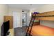Bright bedroom showcasing a bunk bed, TV, closet, and plank floors, offering ample space at 15316 Gulf Blvd # 604, Madeira Beach, FL 33708