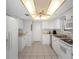 Bright kitchen features white appliances, cabinets, and a unique coffered ceiling with a fan at 15316 Gulf Blvd # 604, Madeira Beach, FL 33708