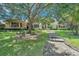 Two-story house with stone accents and a large tree in the front yard at 2690 Keystone Rd, Tarpon Springs, FL 34688