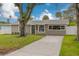 Tan house with dark brown door and landscaping at 4227 Harrisburg Ne St, St Petersburg, FL 33703