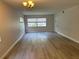 Spacious living room featuring wood-look floors and large windows at 10033 64Th N Ave # 1, St Petersburg, FL 33708