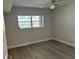 Bright bedroom with large window and wood-look flooring at 10033 64Th N Ave # 1, St Petersburg, FL 33708
