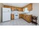 Functional kitchen with wood cabinets and a white stove at 3423 Eisenhower Dr, Holiday, FL 34691
