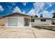 White brick ranch home with a single car garage and a spacious driveway at 3423 Eisenhower Dr, Holiday, FL 34691