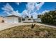Front view of a ranch-style house with white brick facade and a curved driveway at 3423 Eisenhower Dr, Holiday, FL 34691