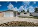 Single story home with white brick exterior and attached garage at 3423 Eisenhower Dr, Holiday, FL 34691