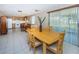 Bright dining room with wood table and chairs, adjacent to the kitchen at 3423 Eisenhower Dr, Holiday, FL 34691