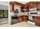 Cozy kitchen featuring wood cabinets, modern appliances, and view to backyard at 33466 Westwood Dr Dr, Ridge Manor, FL 33523