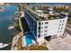 Aerial view of a modern condo building with rooftop amenities and waterfront access at 400 150Th Ave # 304, Madeira Beach, FL 33708