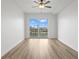 Bright bedroom features wood flooring and large glass doors leading to a private balcony with a water view at 400 150Th Ave # 304, Madeira Beach, FL 33708