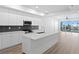 Bright, modern kitchen with stainless steel appliances, island, and sliding doors to balcony at 400 150Th Ave # 304, Madeira Beach, FL 33708