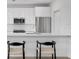 Contemporary kitchen with white cabinets, stainless steel appliances, and seating at the counter at 400 150Th Ave # 304, Madeira Beach, FL 33708
