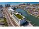 Aerial view showcases a waterfront condo building with a rooftop patio and adjacent marina at 400 150Th Ave # 305, Madeira Beach, FL 33708
