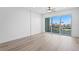 Spacious bedroom featuring hardwood floors and large sliding doors to a balcony with a view at 400 150Th Ave # 305, Madeira Beach, FL 33708