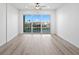 Bright bedroom with a ceiling fan and large sliding glass doors to balcony overlooking water at 400 150Th Ave # 305, Madeira Beach, FL 33708