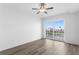 A bright, minimalist bedroom with wood-look floors and access to a balcony through sliding glass doors at 400 150Th Ave # 305, Madeira Beach, FL 33708